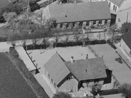 Luftfoto fra ca 1938. Farven på murstene der er brugt til den lille sal adskiller sig tydeligt fra resten af huset. Den lille sal blev bygget i 1937 og er derfor på dette tidspunkt helt nybygget. Sylvest Jensen luftfoto. Det kongelige bibliotek.